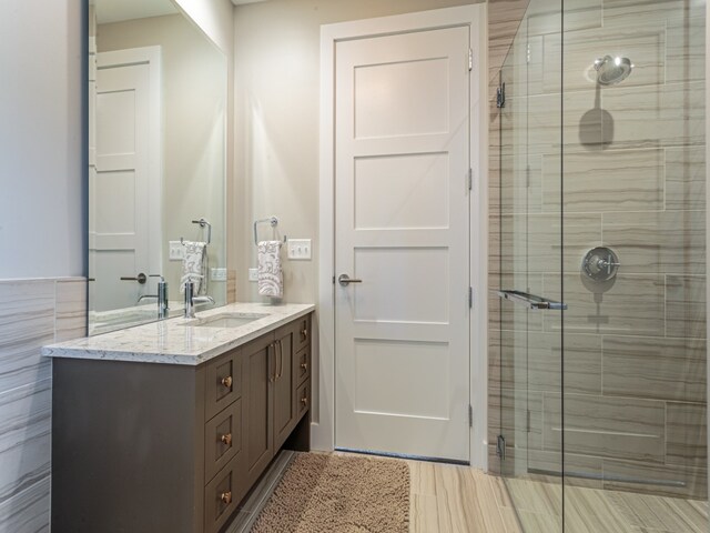 bathroom featuring vanity, tile walls, and walk in shower