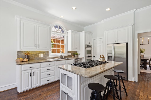 kitchen featuring light stone countertops, a center island, stainless steel appliances, sink, and dark wood-type flooring