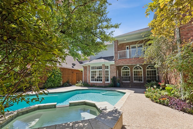 view of swimming pool with an in ground hot tub