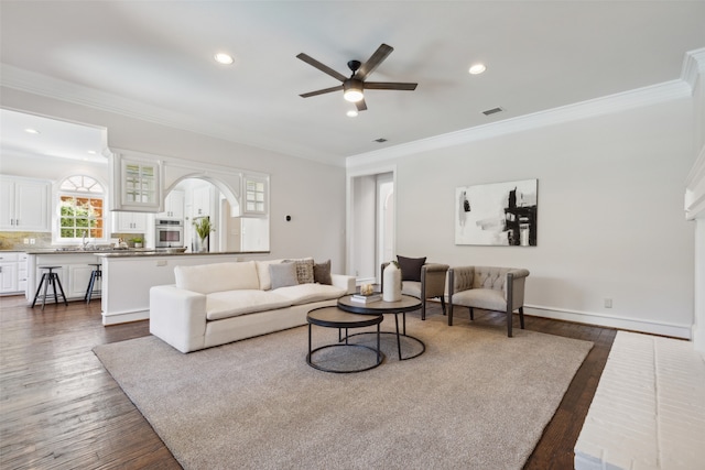 living room featuring ceiling fan, dark hardwood / wood-style floors, crown molding, and sink