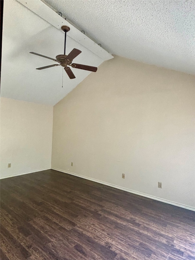 empty room featuring ceiling fan, lofted ceiling with beams, and dark wood-type flooring