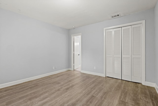 unfurnished bedroom with hardwood / wood-style floors and a closet