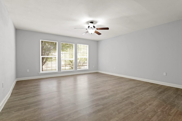 spare room with ceiling fan and dark wood-type flooring