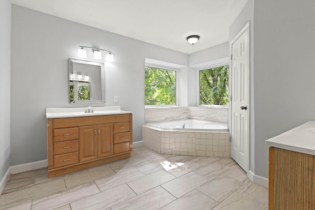 bathroom featuring vanity and a relaxing tiled tub