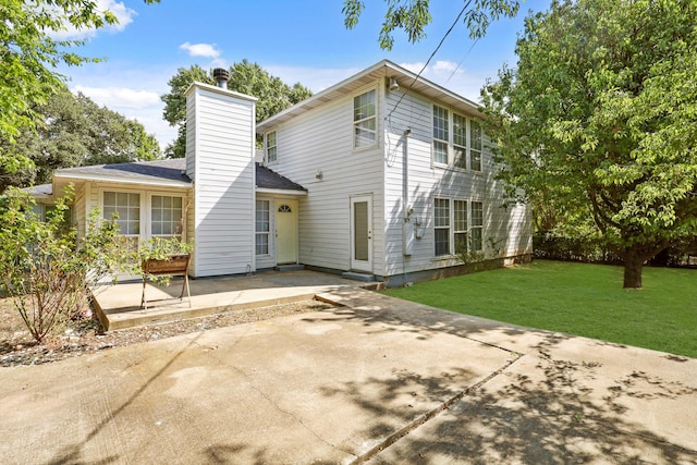 back of house with a yard and a patio