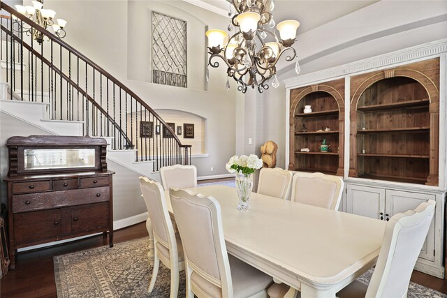 dining area with a notable chandelier, dark wood-type flooring, and built in shelves