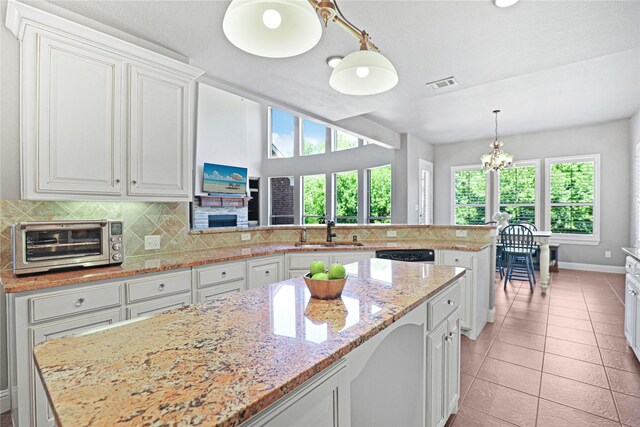 kitchen featuring plenty of natural light, sink, kitchen peninsula, and backsplash