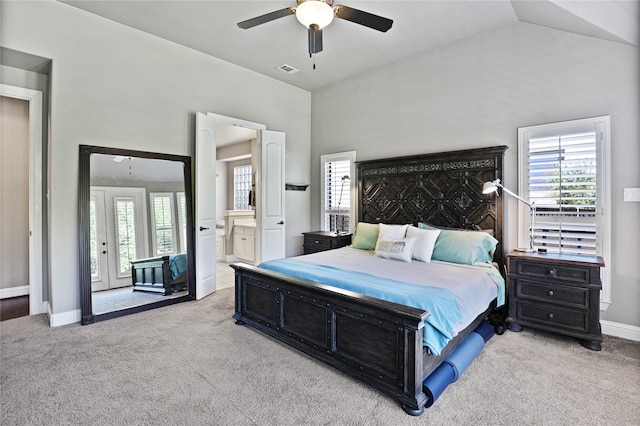 carpeted bedroom with ceiling fan, vaulted ceiling, and ensuite bath