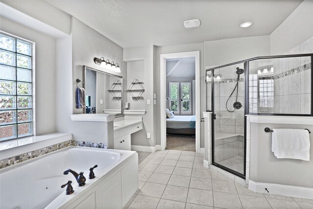 bathroom featuring tile patterned flooring, vanity, and separate shower and tub