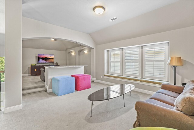 carpeted living room with lofted ceiling