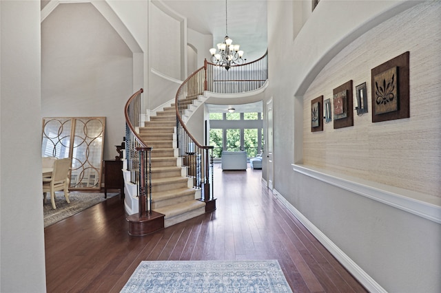 foyer entrance featuring a chandelier, dark hardwood / wood-style floors, and a high ceiling