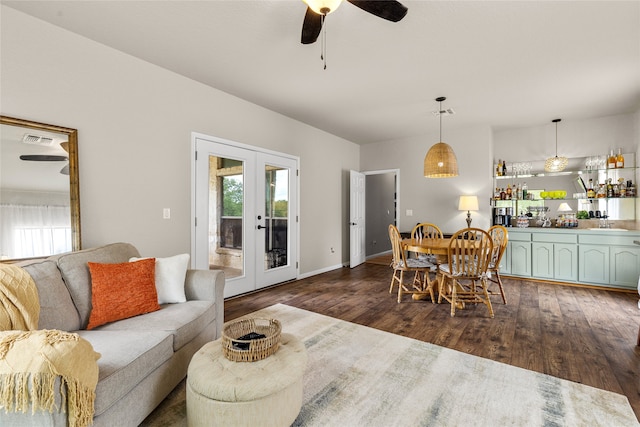 living room featuring ceiling fan, dark hardwood / wood-style floors, indoor bar, and french doors