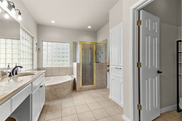 bathroom with tile patterned flooring, vanity, and shower with separate bathtub