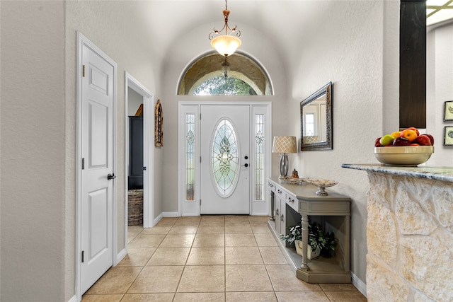 tiled entryway featuring vaulted ceiling