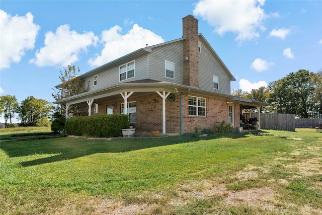 rear view of property featuring a porch and a lawn