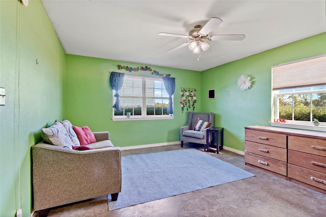 living area with a wealth of natural light, concrete floors, and ceiling fan