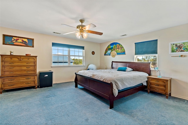 bedroom with multiple windows, ceiling fan, and carpet