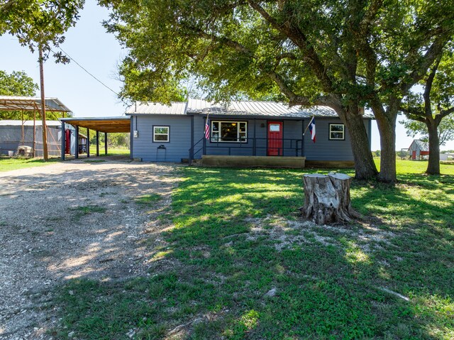 ranch-style house featuring a front lawn and a carport