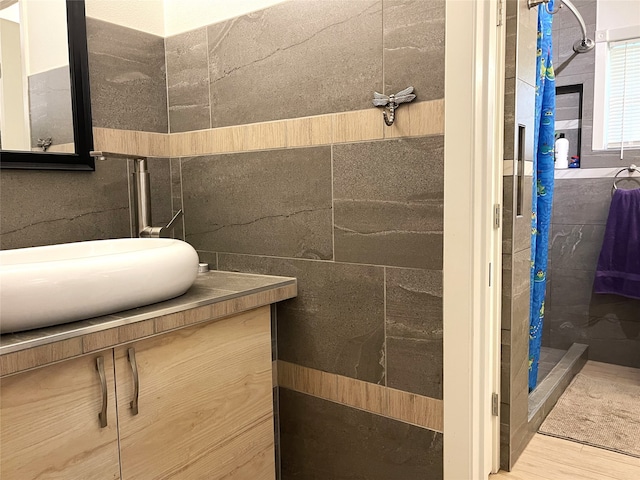 bathroom featuring walk in shower, hardwood / wood-style flooring, and vanity