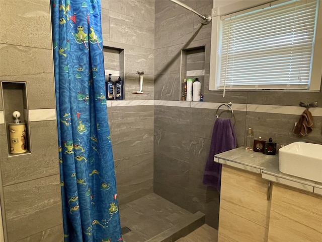 bathroom featuring tile walls, walk in shower, and vanity