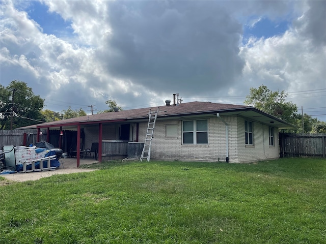 rear view of house featuring a lawn