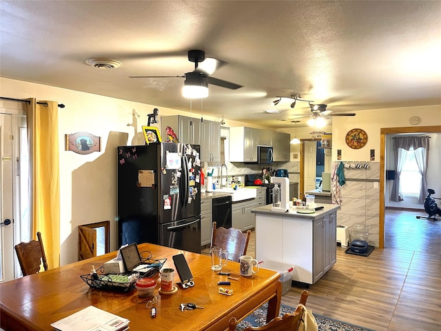 dining room featuring a textured ceiling, light hardwood / wood-style flooring, and ceiling fan