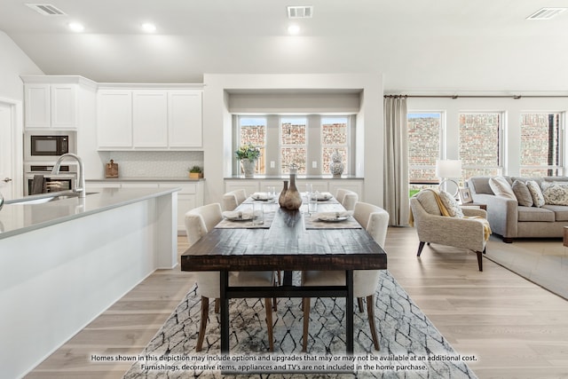 dining room with light hardwood / wood-style flooring and sink