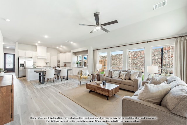 living room featuring ceiling fan, light wood-type flooring, and vaulted ceiling