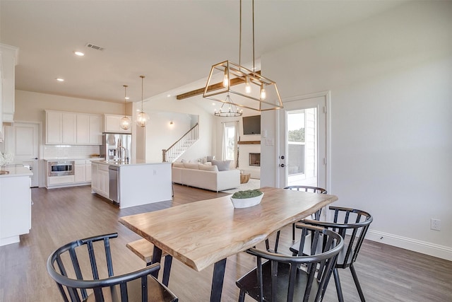 dining area featuring dark hardwood / wood-style flooring and vaulted ceiling