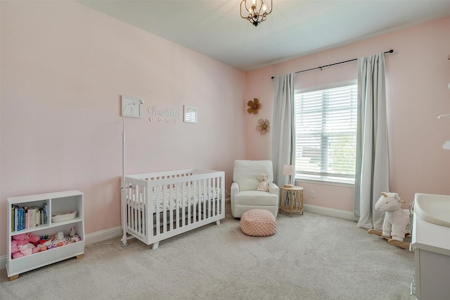 carpeted bedroom featuring a nursery area