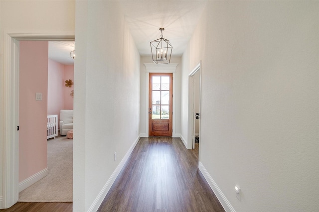 doorway to outside featuring dark hardwood / wood-style floors and an inviting chandelier