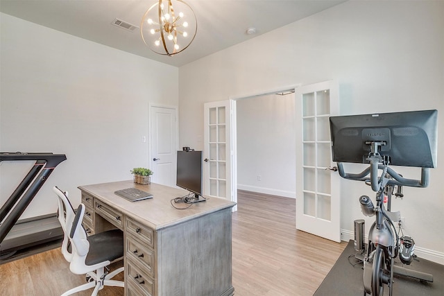 office area featuring a chandelier, french doors, and light hardwood / wood-style flooring