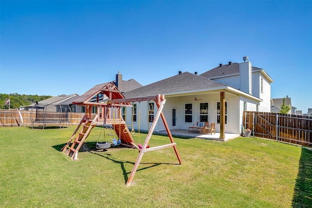 view of play area featuring a lawn, a patio area, and a trampoline