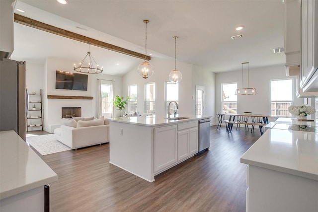 kitchen featuring stainless steel appliances, white cabinetry, an island with sink, and hanging light fixtures