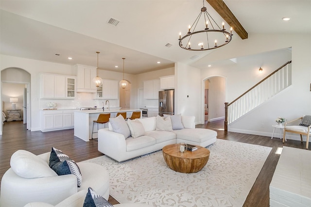 living room with a notable chandelier, lofted ceiling with beams, dark hardwood / wood-style flooring, and sink