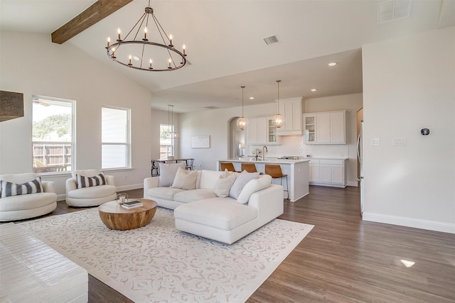 living room featuring beam ceiling, sink, an inviting chandelier, high vaulted ceiling, and dark hardwood / wood-style floors