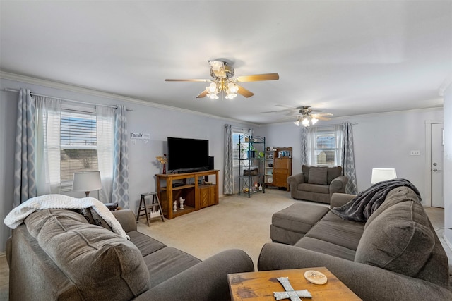 living room featuring a healthy amount of sunlight, a ceiling fan, crown molding, and light colored carpet