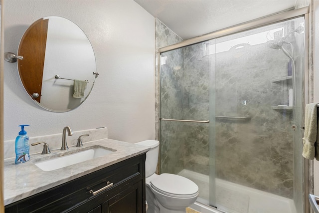 full bath featuring vanity, a shower stall, and toilet