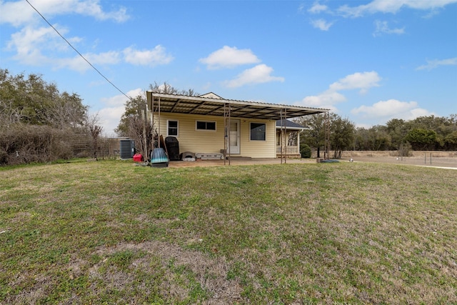 rear view of house featuring central AC, a yard, a patio, and metal roof