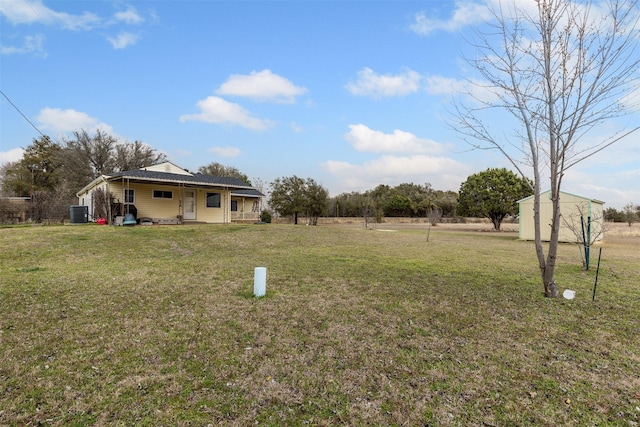 view of yard featuring covered porch, central AC unit, and an outdoor structure