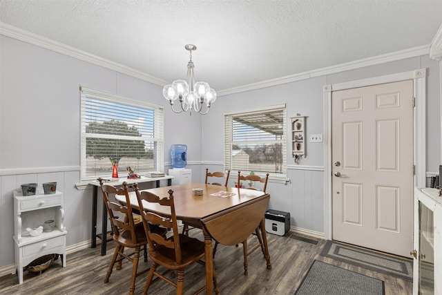 dining room with dark wood-type flooring, wainscoting, ornamental molding, and a textured ceiling