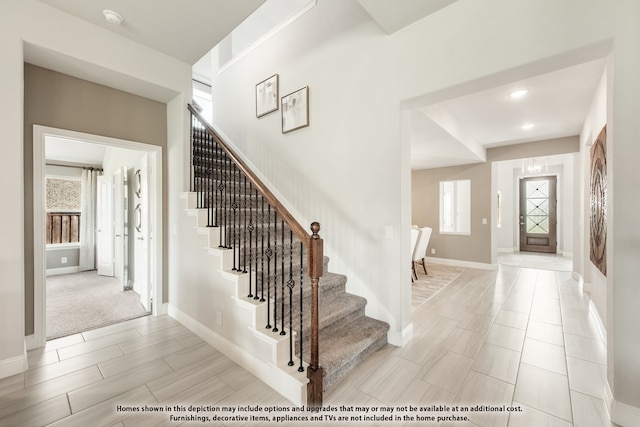 foyer entrance featuring plenty of natural light and light colored carpet