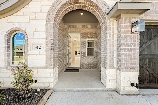 entrance to property featuring stone siding and brick siding