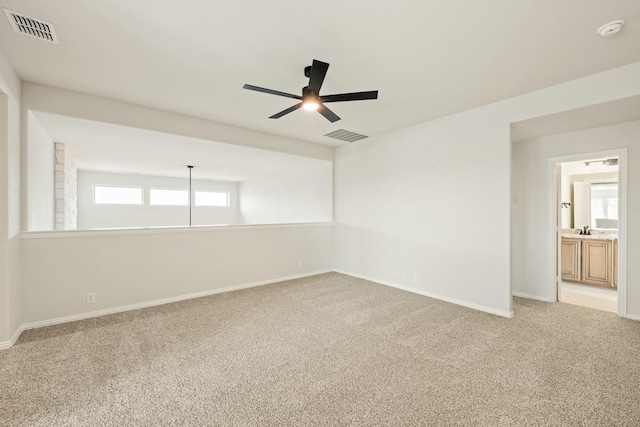 carpeted empty room featuring sink and ceiling fan