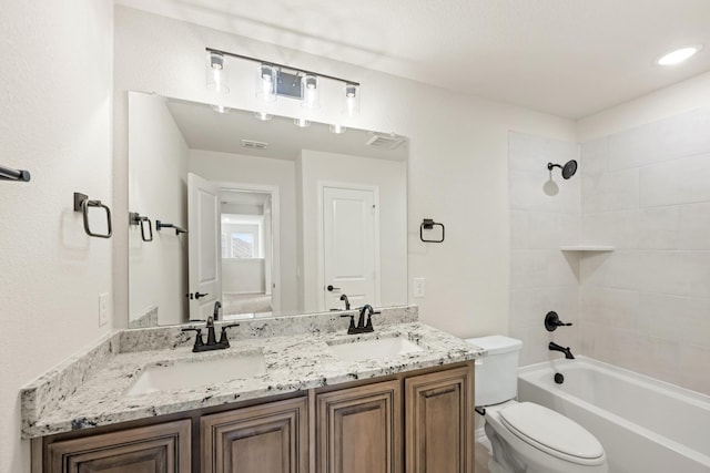 full bathroom featuring tiled shower / bath combo, vanity, and toilet