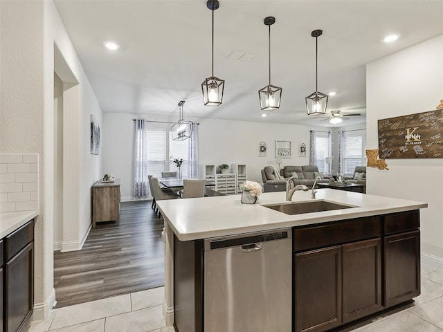 kitchen featuring light hardwood / wood-style floors, sink, an island with sink, ceiling fan, and stainless steel dishwasher