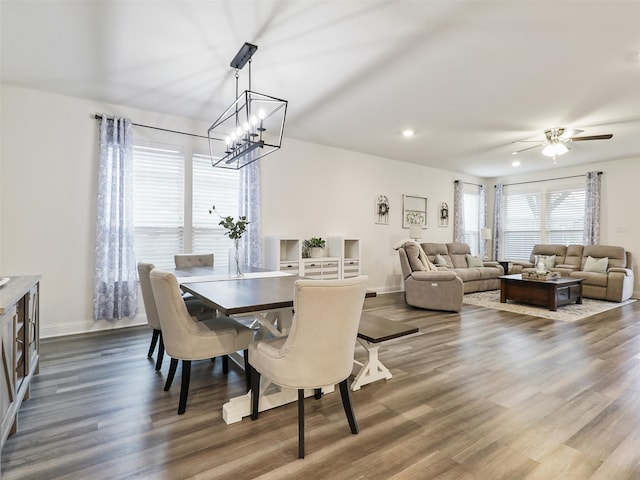 dining room with hardwood / wood-style floors and ceiling fan with notable chandelier