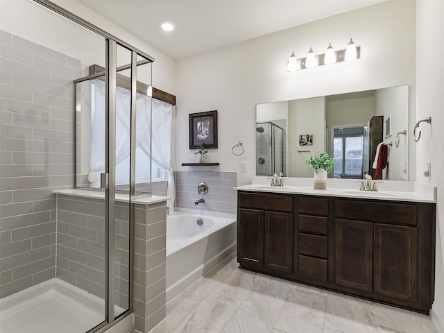 bathroom with vanity and shower with separate bathtub