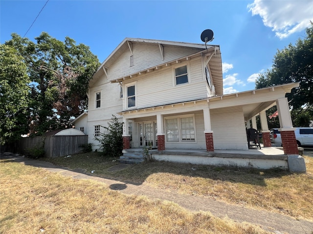 rear view of property featuring a yard and a porch