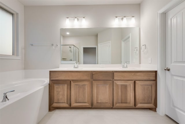 bathroom with tile patterned flooring, vanity, and separate shower and tub